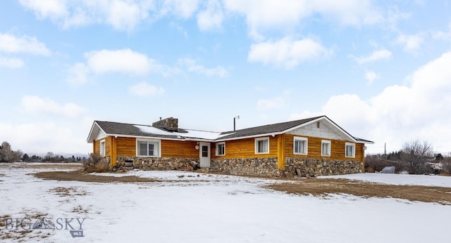 view of front of property with stone siding and a chimney