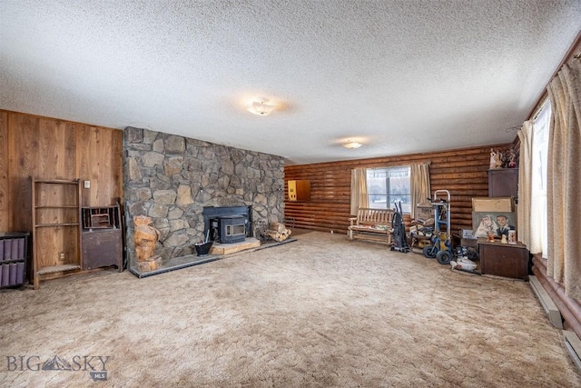 unfurnished living room featuring wooden walls, a wood stove, a textured ceiling, rustic walls, and carpet flooring