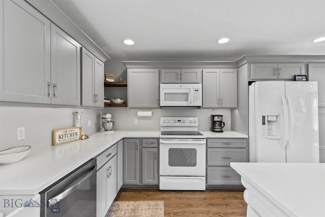 kitchen with dark wood-type flooring, gray cabinetry, and white appliances