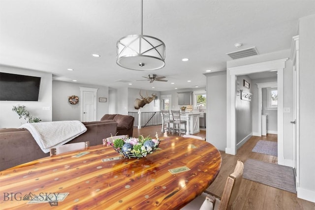 dining space with ceiling fan and light wood-type flooring