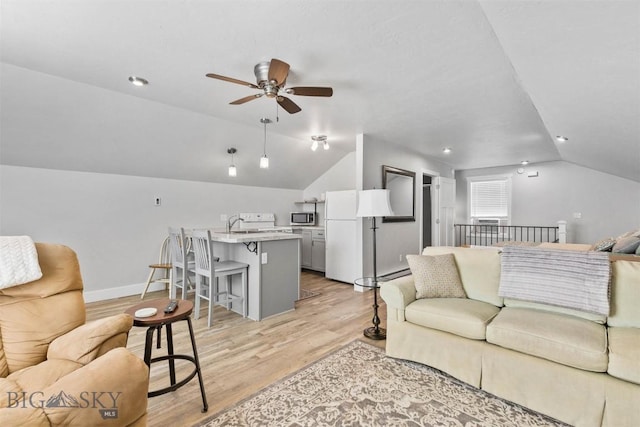 living room with vaulted ceiling, ceiling fan, and light wood-type flooring