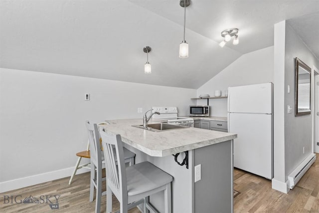 kitchen with sink, white appliances, a breakfast bar, baseboard heating, and hanging light fixtures