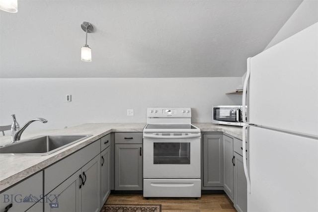 kitchen with sink, gray cabinetry, white appliances, and decorative light fixtures