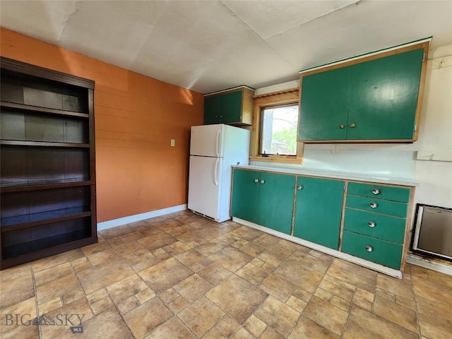 kitchen with green cabinets and white fridge