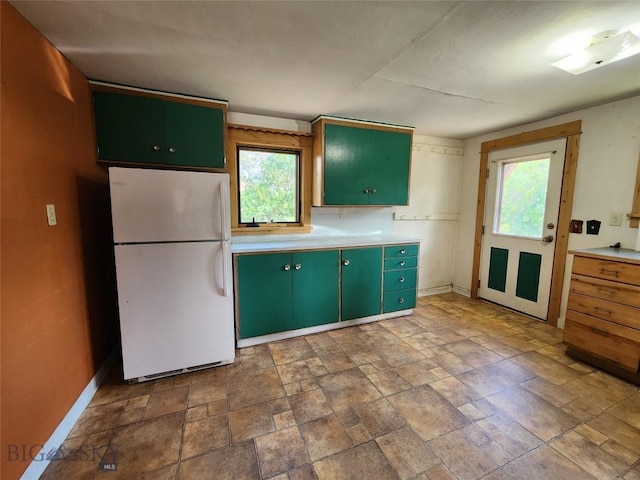 kitchen featuring green cabinets and white refrigerator