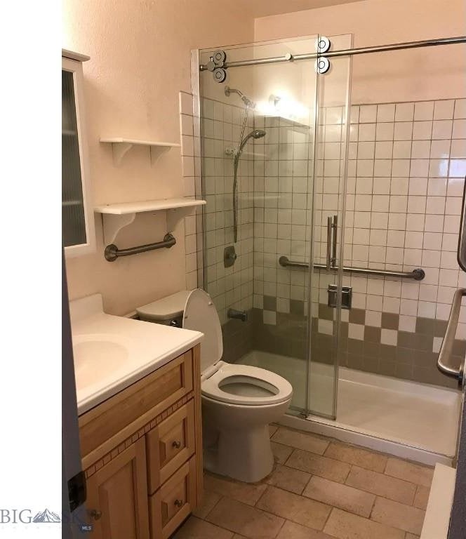 full bath featuring vanity, a shower stall, and toilet