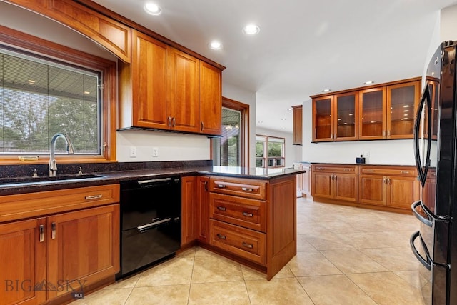 kitchen featuring black appliances, dark stone countertops, sink, kitchen peninsula, and light tile patterned floors