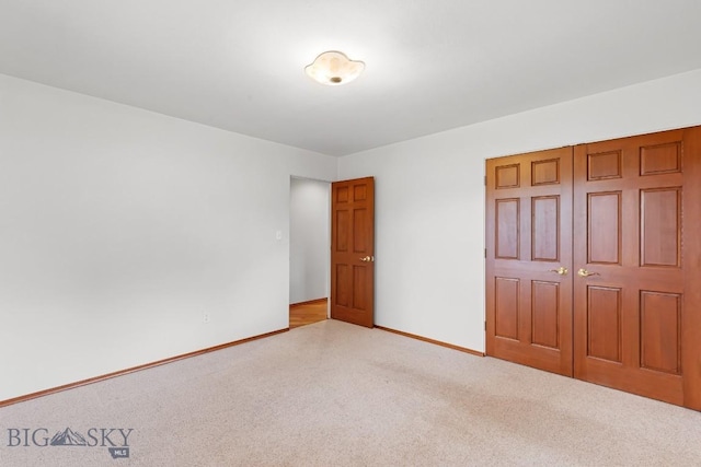 unfurnished bedroom with a closet and light carpet