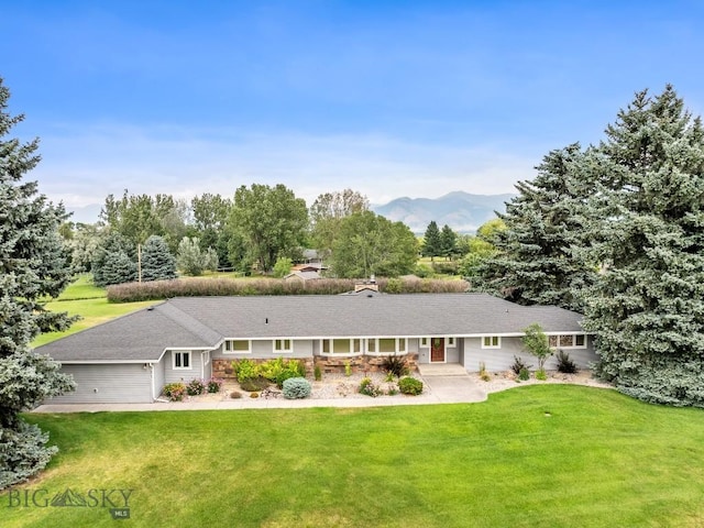 view of front facade featuring a mountain view, a front yard, and a garage