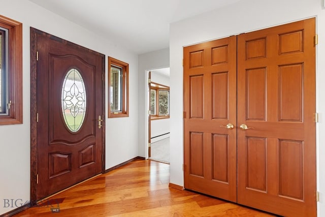 entrance foyer featuring light wood-type flooring and a baseboard heating unit