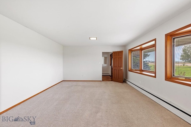 carpeted empty room with a baseboard heating unit