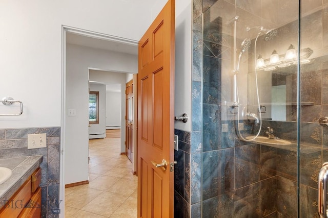 bathroom with a baseboard radiator, tile walls, tile patterned floors, walk in shower, and vanity