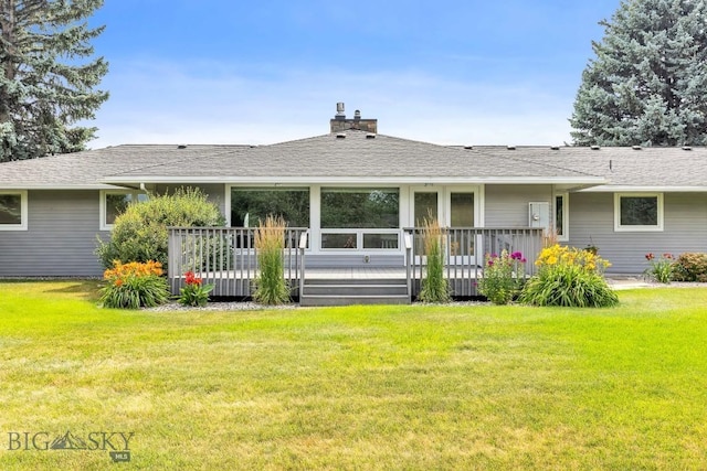 back of property featuring a wooden deck and a lawn