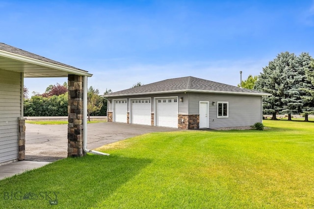 exterior space featuring a garage, a lawn, and an outdoor structure