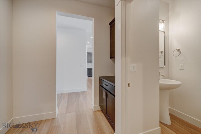 hallway with light hardwood / wood-style floors