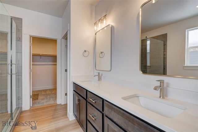 bathroom featuring a shower with shower door, wood-type flooring, and vanity