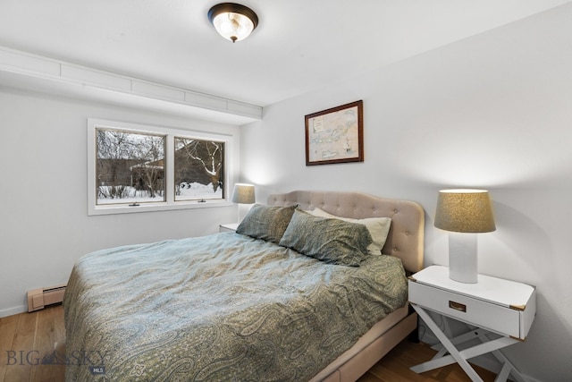 9 Park Plaza Rd, Bozeman, MT 59715 - bedroom with baseboards, a baseboard radiator, and wood finished floors