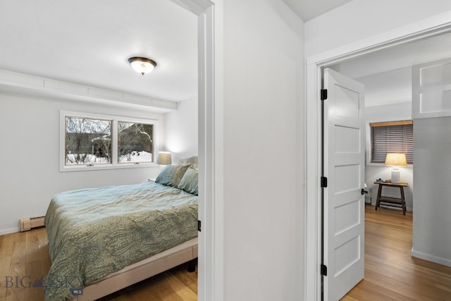 9 Park Plaza Rd, Bozeman, MT 59715 - bedroom featuring baseboards, wood finished floors, and a baseboard radiator