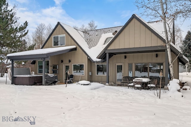 9 Park Plaza Rd, Bozeman, MT 59715 - snow covered rear of property featuring board and batten siding, a hot tub, and a patio area