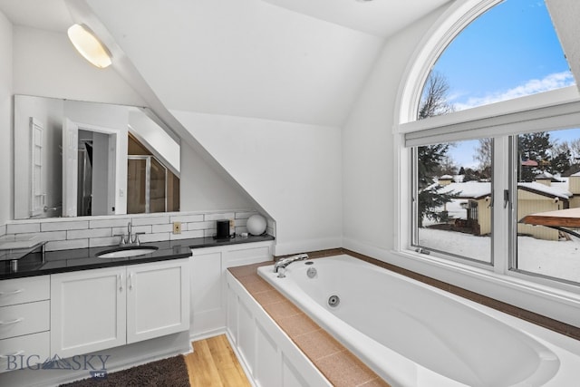 9 Park Plaza Rd, Bozeman, MT 59715 - bathroom with vaulted ceiling, a jetted tub, vanity, a shower stall, and wood finished floors