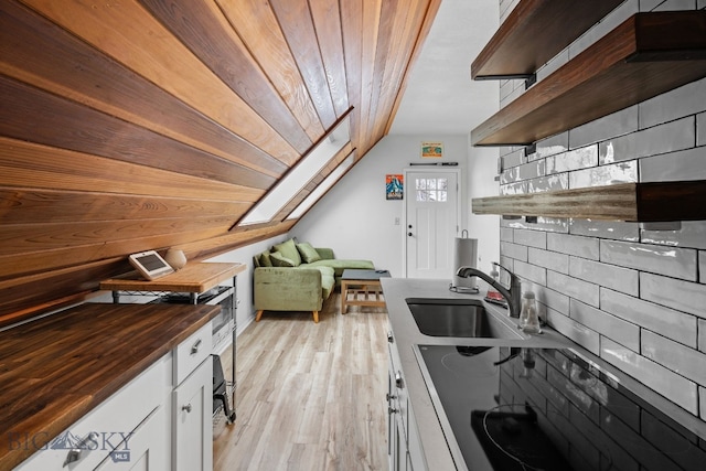 9 Park Plaza Rd, Bozeman, MT 59715 - kitchen with open shelves, butcher block counters, light wood-type flooring, white cabinetry, and a sink