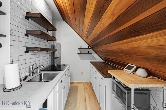 9 Park Plaza Rd, Bozeman, MT 59715 - kitchen with open shelves, white cabinetry, tasteful backsplash, a sink, and light wood finished floors