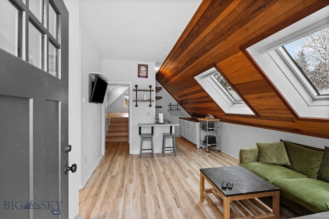 9 Park Plaza Rd, Bozeman, MT 59715 - living area featuring baseboards, light wood-style flooring, stairs, and vaulted ceiling with skylight