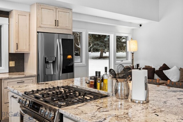 9 Park Plaza Rd, Bozeman, MT 59715 - kitchen with stainless steel appliances, light stone countertops, light brown cabinets, and decorative backsplash