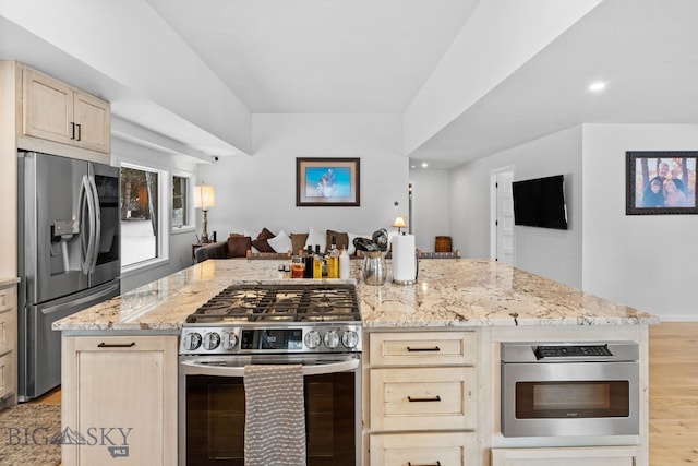 9 Park Plaza Rd, Bozeman, MT 59715 - kitchen featuring appliances with stainless steel finishes, light brown cabinets, light stone countertops, and open floor plan