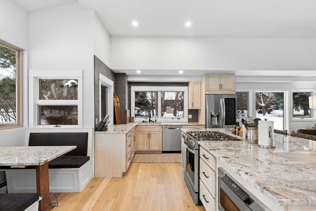 9 Park Plaza Rd, Bozeman, MT 59715 - kitchen with light stone counters, light brown cabinets, stainless steel appliances, recessed lighting, and light wood-type flooring
