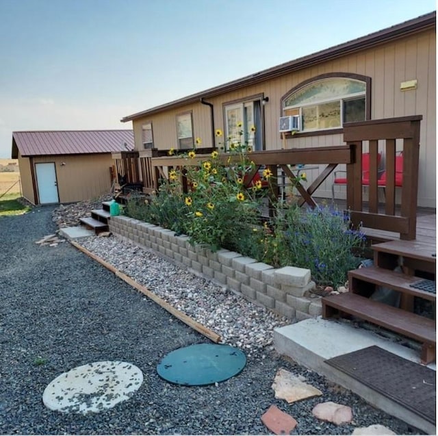 rear view of house featuring a deck and a storage shed