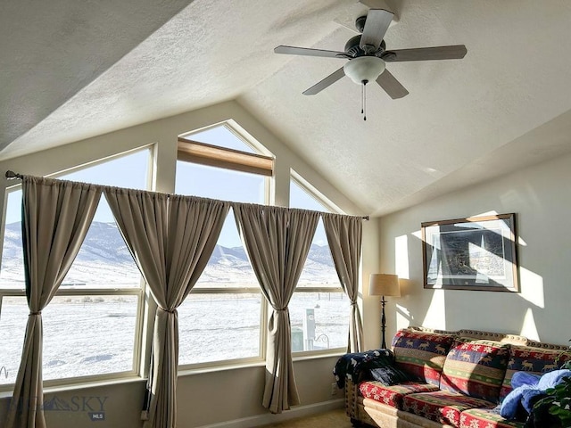 interior space featuring lofted ceiling, a mountain view, a textured ceiling, and ceiling fan