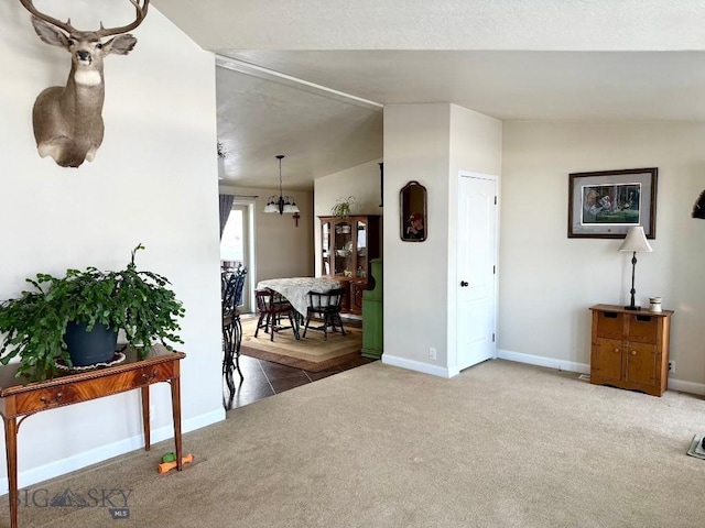 interior space featuring lofted ceiling, a chandelier, and carpet floors