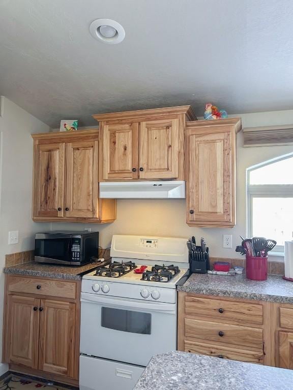 kitchen featuring lofted ceiling and white gas stove