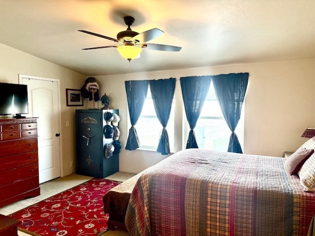 carpeted bedroom with multiple windows, lofted ceiling, and ceiling fan