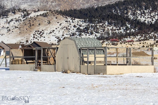 snow covered structure with a mountain view