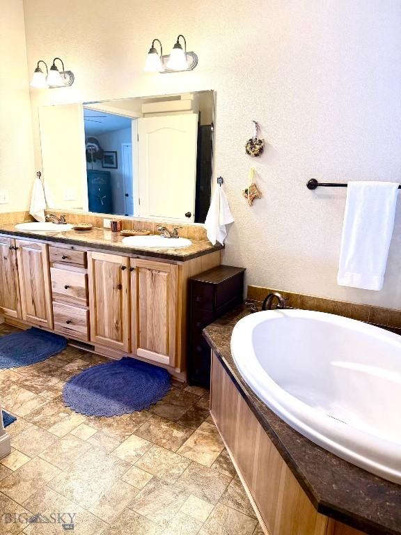 bathroom featuring vanity and a bath