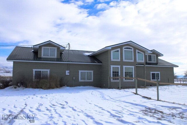 view of snow covered rear of property