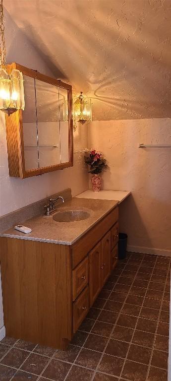 bathroom featuring vaulted ceiling and vanity