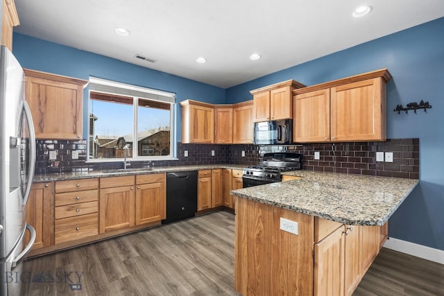 kitchen with wood-type flooring, sink, kitchen peninsula, and black appliances