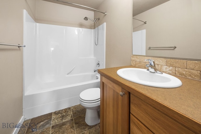 full bathroom with shower / bathtub combination, stone finish flooring, vanity, and toilet