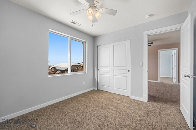 unfurnished bedroom with ceiling fan, carpet flooring, visible vents, baseboards, and a closet