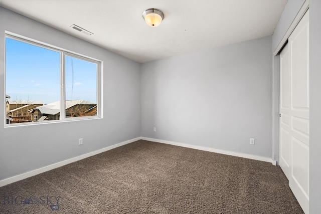 unfurnished bedroom featuring a closet, carpet flooring, visible vents, and baseboards