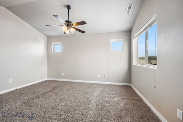 spare room with carpet floors, a ceiling fan, visible vents, and baseboards