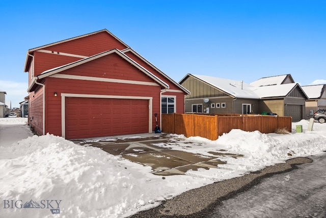 view of front of house with an attached garage and fence