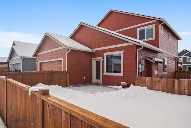 view of front of home featuring an attached garage and fence