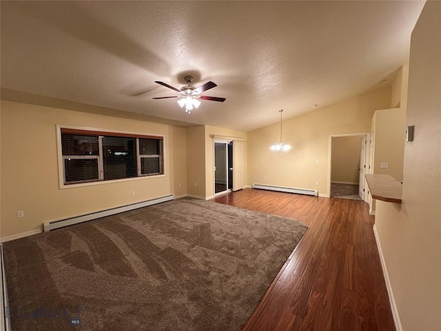 spare room with vaulted ceiling, dark wood-type flooring, ceiling fan with notable chandelier, and a baseboard radiator