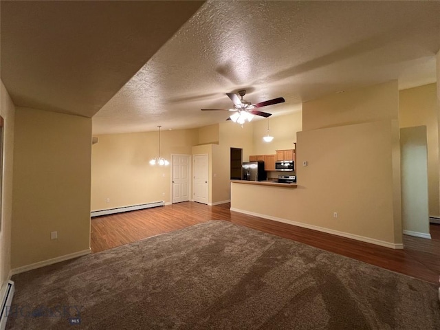 unfurnished living room featuring baseboard heating, ceiling fan with notable chandelier, a textured ceiling, and wood-type flooring