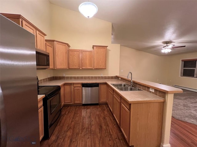 kitchen with kitchen peninsula, ceiling fan, appliances with stainless steel finishes, dark hardwood / wood-style floors, and sink