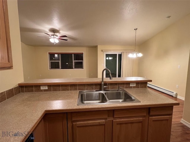 kitchen featuring decorative light fixtures, sink, dark wood-type flooring, ceiling fan with notable chandelier, and a baseboard radiator